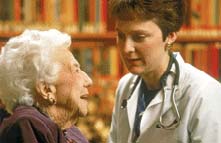 Photo of a doctor examining an older woman.